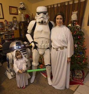 Allan Quick (center), 3-year-old daughter Rachel and wife Karyn are looking forward to seeing the premiere of “Star Wars: The Force Awakens” — but they won’t be wearing their full costumes because of theater and mall restrictions on elements of the spirited getups. (Chris Pietsch/The Register-Guard)