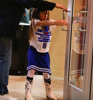 Savannah Jones, dressed as R2D2, rushes into the theater to attend "Star Wars: The Force Awakens" Thursday night, December 17, 2015 in Tuscaloosa. Staff Photo | Gary Cosby Jr.