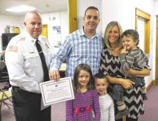 Lakeville Police Chief Frank Alvilhiera presented William Driscoll with a citation in October 2014 for his heroic action by using his vehicle to push another vehicle off the road, preventing a head-on collision. Present for the award were Mr. Driscoll's wife, Kristen, and their children, Dominic, Gabrien, and Natalia.