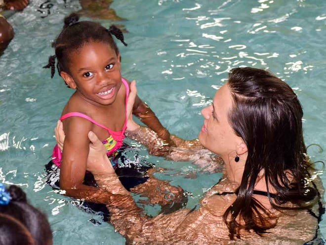 A young student from St. Pius V Catholic School looks delighted to be participating in swim lessons as part of a special YMCA program.