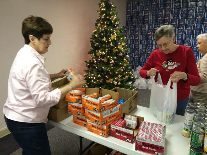 Linda Jackson, left, and Diane McSwain, help to prepare bags of groceries Thursday morning at East Baptist Church in Gas-tonia. The church is preparing for its 15th annual Christmas Feast. Hot meals, food, clothing and toys will be given out Thurs-day and Friday to people in need. (Michael Barrett/The Gazette)