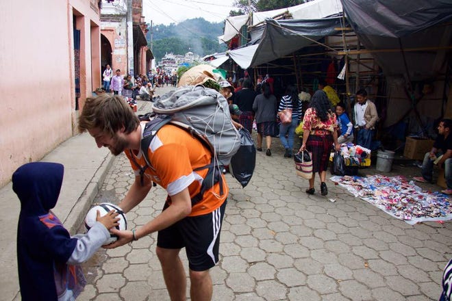 Holland's Kyler Beal hands out a soccer ball to a child in Guatemala. Contributed