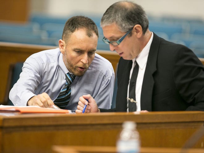 Dustin Heathman, left, talks with defense attorney Peter Sziklai during his trial in Ocala on Tuesday.