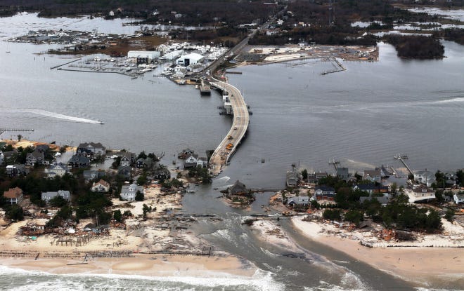 Hurricane Sandy ripped up roadways and obliterated houses when it slammed the Mid-Atlantic coastline in October 2012. Pictured here is the damage in Seaside Heights, N.J. Climate scientists expect violent storms to become more common as the planet warms. DOUG MILLS/AP FILE PHOTO
