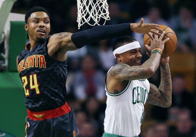Atlanta's Kent Bazemore blocks a shot by Boston's Isaiah Thomas during the first quarter of Friday's game. The Associated Press