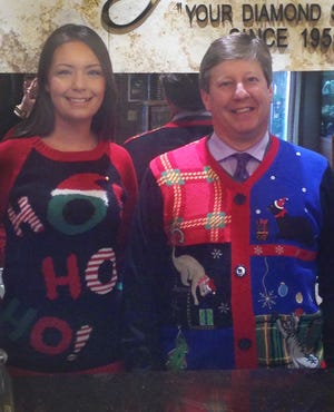 Wally Hinkamp, right, dons his ugly sweater for promotion to assist the needy. At left is Amanda Shackleford, a sales associate and office manager at Hinkamp Jewelers in McPherson Square.