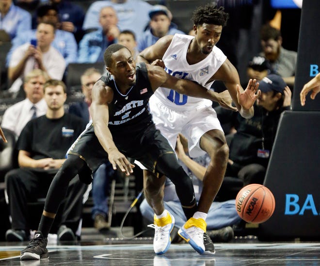 North Carolina's Theo Pinson (1) and UCLA's Isaac Hamilton (10) fight for the ball during the first half of an NCAA college basketball game Saturday, Dec. 19, 2015, in New York.