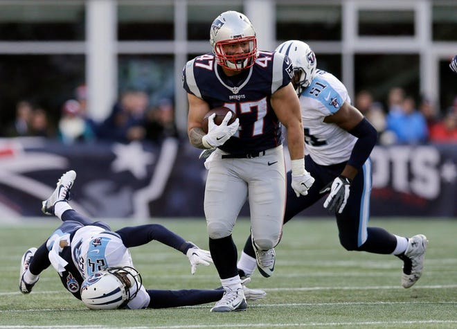 New England Patriots running back Joey Iosefa (47) runs from Tennessee Titans cornerback Coty Sensabaugh (24) and linebacker David Bass (51) in the first half of their game Sunday in Foxborough, Mass. Photo by AP