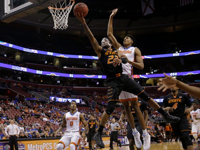 Oklahoma State 's Jeff Newberry (22) shoots in front of Florida 's Brandone Francis-Ramirez in the first half of the college Orange Bowl Basketball Classic, Saturday, Dec. 19, 2015, in Sunrise.