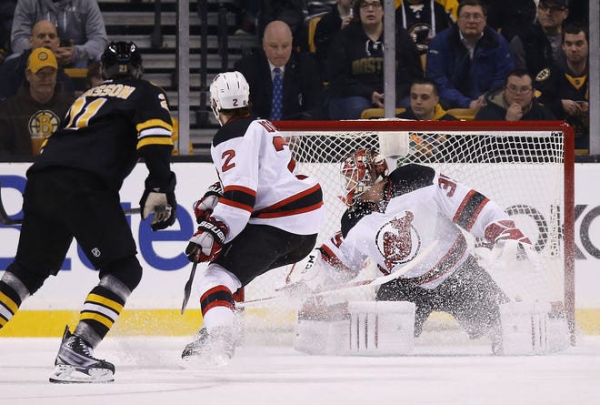 Boston's Loui Eriksson scores on New Jersey's Cory Schneider in the first period of Sunday's game. The Associated Press