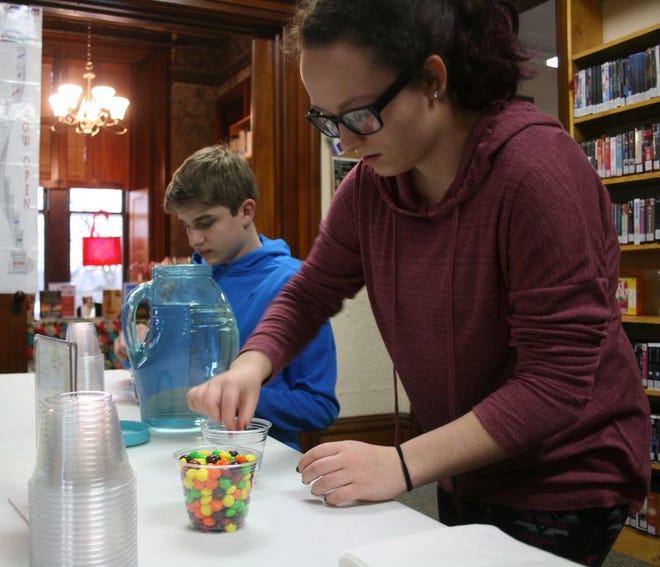 Tapaynga Brassell, 13 (right) and Grayson Barrigear, 13, take part in "The Science of Candy" at the Ionia Community library. The library will be hosting events to entertain area children during Christmas break.