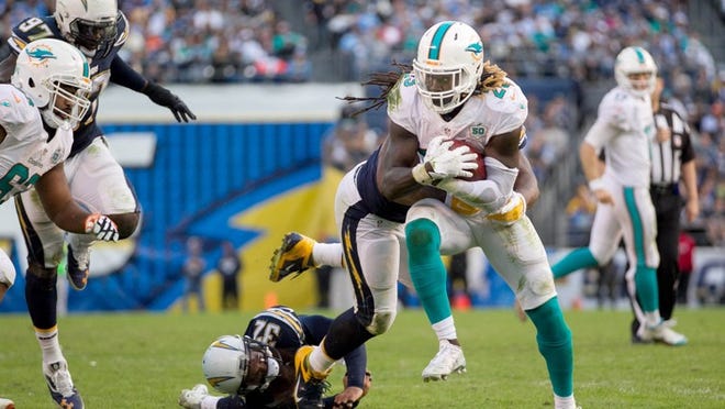Miami Dolphins running back Jay Ajayi (23) breaks tackles on a touchdown run in the third quarter at Qualcomm Stadium in San Diego, California on December 20, 2015. (Allen Eyestone / The Palm Beach Post)