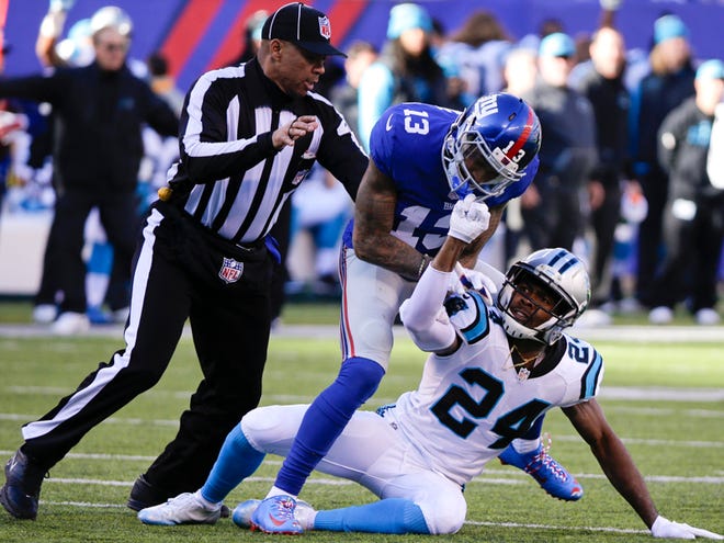 In this Dec. 20, 2015, file photo, a referee, left, separates New York Giants wide receiver Odell Beckham (13) and Carolina Panthers' Josh Norman (24) during the first half of an NFL football game Sunday, Dec. 20, 2015, in East Rutherford, N.J.