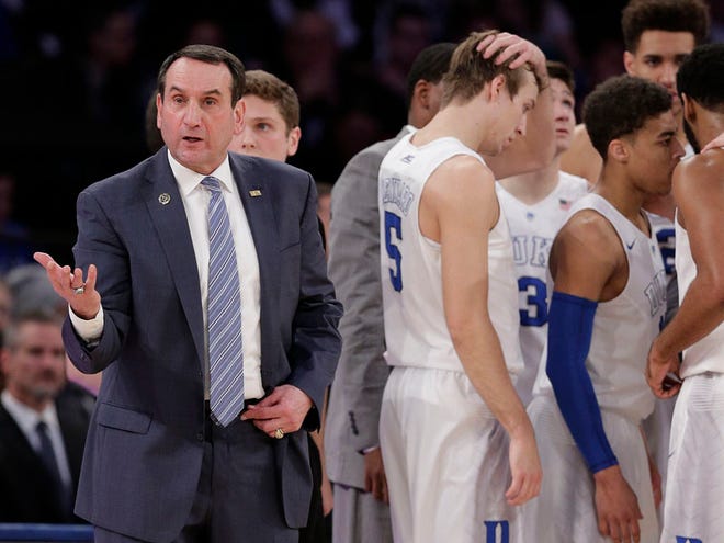 Duke head coach Mike Krzyzewski looks to the referee for a goal tending call as the team gathers during a timeout in the first half of an NCAA college basketball game against Utah, Saturday, Dec. 19, 2015, in New York.