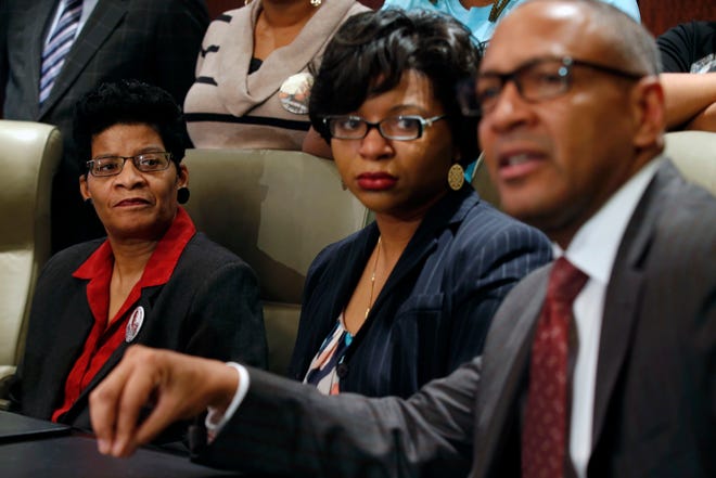 Geneva Reed-Veal, left, and Sharon Cooper, center, the mother and sister of Sandra Bland, listen to attorney Larry Rogers Jr., right, explain concerns about the Texas grand jury's role in the death of Naperville resident Sandra Bland, Monday, Dec. 21, 2015 in Chicago. As a grand jury investigates the case of Sandra Bland, a black woman whose death in a Texas jail shook a raw year in American policing, the state police force at the center of her combative traffic stop is able to shield some complaints under special exemptions and has used what experts say are outdated practices for keeping nearly 4,000 troopers in check. (Phil Velasquez/Chicago Tribune via AP)