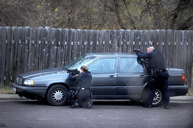 Columbia police officers take positions Monday on Lakeview Avenue during a search for two suspects in an armed robbery.