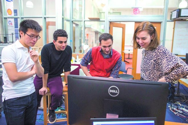 Scott Eisen/The Associated Press- Massachusetts Institute of Technology researchers, from left, Chen-Yu Hsu, Emad Farag and Fadel Adib view data on Nov. 19 from their RF-Capture device with professor Dina Katabi, right, in their lab at MIT in Cambridge, Mass.