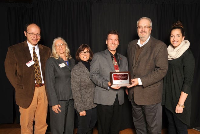 Chief of Conservation Ted Lozier and MWCD Chief Engineer Boris Slogar hold the award, accompanied by the OSU-Extension team.