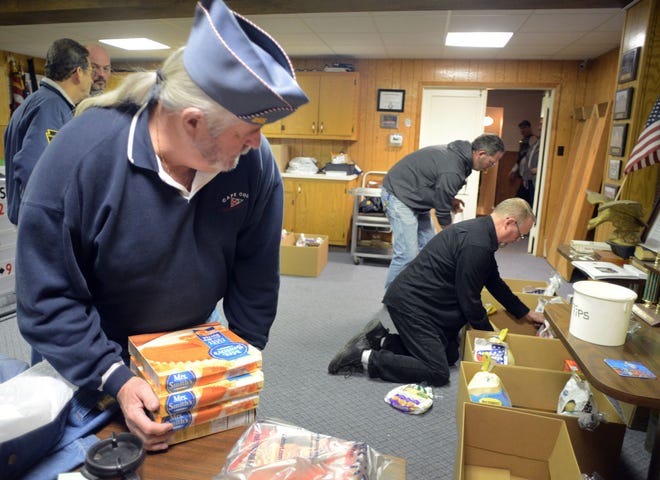 (Front to back) Dave Hanshew of Sellersville, Bob Dager of Perkasie and Tony Hess of Trumbauersville load boxes of food as members of the American Legion Sellersville Post prepare to deliver Christmas meals to needy families Saturday Dec. 19, 2015, in Sellersville.