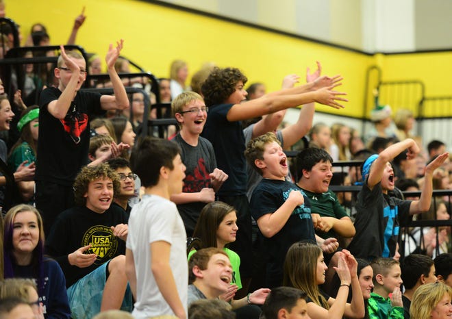 Seventh-graders at Highland Middle School react as their classmates make a point during the seventh grade versus eighth grade volleyball game Tuesday during the school's annual Give a Christmas assembly.