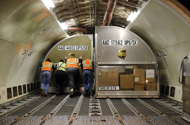 Once a container is full, UPS workers push it into the belly of a cargo jet at their air-shipping hub at the Louisville, Ky., airport.