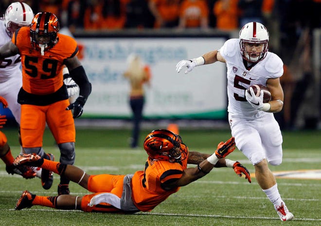 FILE - In this Sept. 25, 2015, file photo, Stanford's Christian McCaffrey, right, gets past an Oregon State defender during the first half of an NCAA college football game in Corvallis, Ore. McCaffrey was selected as The Associated Press college football player of the year on Tuesday, Dec. 22, 2015, becoming the first non-Heisman Trophy winner to earn the honor in six years. (AP Photo/Timothy J. Gonzalez, File)