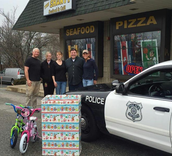 Toy drive orgainzers (left to right) Shanty general manager Jim McKenzie, Karrie Labell, Shanty head bartender Loralise LoDolce, Shanty co-owner Joe Scarlotto, and Detective Jones. Courtesy photo