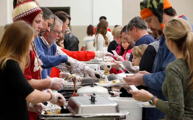 DARON.DEAN@STAUGUSTINE.COM Volunteers prepare and serve meals during Rick's Family and Friends 14th annual Christmas Celebration Meal at the National Guard Armory on Thursday morning, December 25, 2014.
