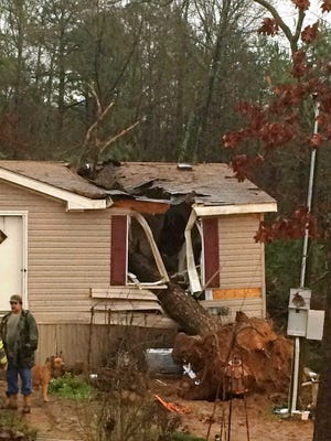This photo provided by the Pope County Sheriff's Department shows a storm damaged home outside of Atkins, Ark., on Wednesday, Dec. 23, 2015. High winds and heavy rain caused a large tree to become uprooted and fall on the house resulting in the death of an 18-year-old woman and trapping her 1-year-old child inside, authorities said. Rescuers pulled the toddler safely from the home. (Pope County Sheriff's Department photo via AP)