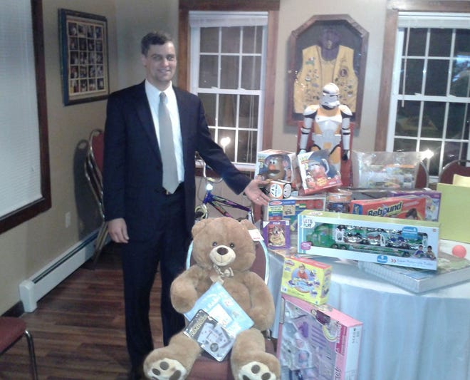 Jason Gerrish, both a Lion and an officer at Eastern Bank, stands with toys collected by the Lakeville Lions for Eastern's Toys for Tots drive. Submitted
