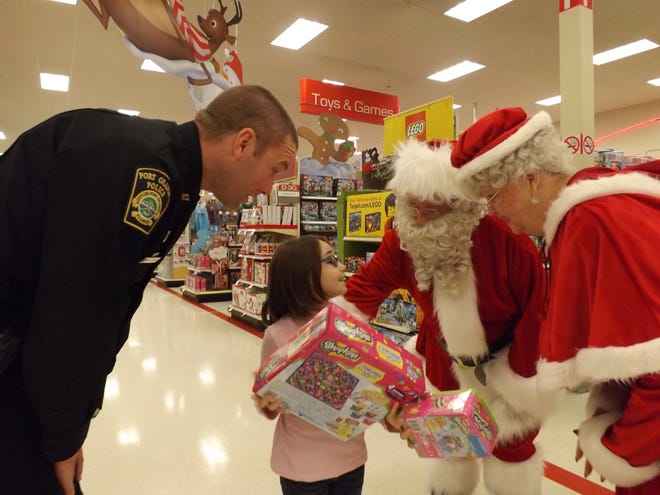 Officer Evan Doyle and Kyaleah Albritton, 8, stop during her shopping spree to talk to Santa and Mrs. Claus.