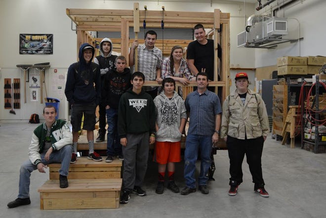 Weed High School construction class students and the frame of the tiny house they're building as this year's class project.