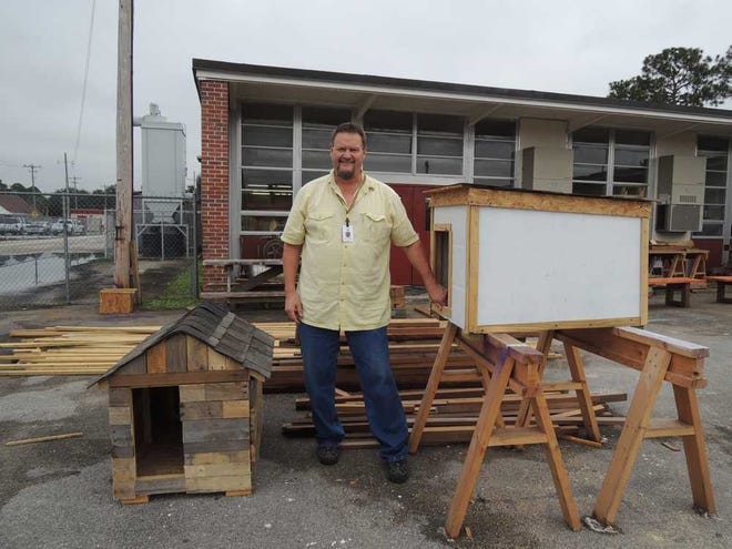 Tiffanie.Reynolds@jacksonville.com Barry Stewart, a building and construction teacher at Englewood High School, displays doghouses that his students have constructed. Stewart's class builds doghouses and feral cathouses to be donated to the community.