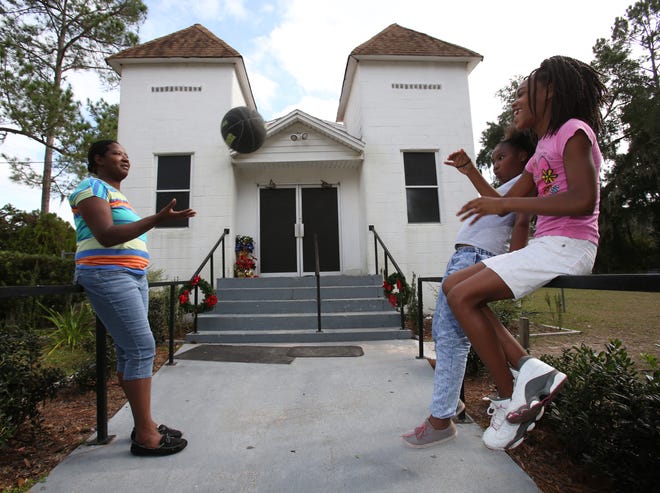 Simyra Hill, a church member, left, plays with her daughter, Shaniya Hill, 9, center, and Jadah Kingcade, 11, a friend, right, as they wait for the Mount Calvary Missionary Baptist Church to open on Southwest College Road in Ocala on Tuesday.