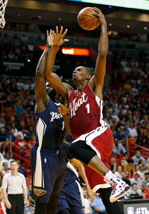 Miami Heat's Chris Bosh (1) goes to the basket against New Orleans Pelicans Tyreke Evans (1) during the second half of an NBA basketball game, Friday, Dec. 25, 2015, in Miami. The Heat defeated the Pelicans 94-88 in overtime. (AP Photo/Joel Auerbach)
