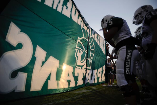 Athens Academy players prepare to run through their banner before the first half of a game between Athens Academy and Athens Christian on Friday, Aug. 28, 2015, in Athens, Ga. (AJ Reynolds/Staff, @ajreynoldsphoto)