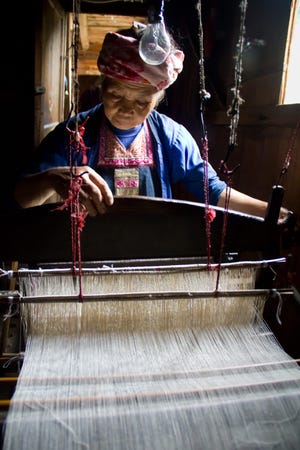 A woman from the Chinese village of Dimen weaves material for one of Singing Hands' products, which are sold to finance community projects in the artisan's village and support the community. PHOTO COURTESY MARIE LEE