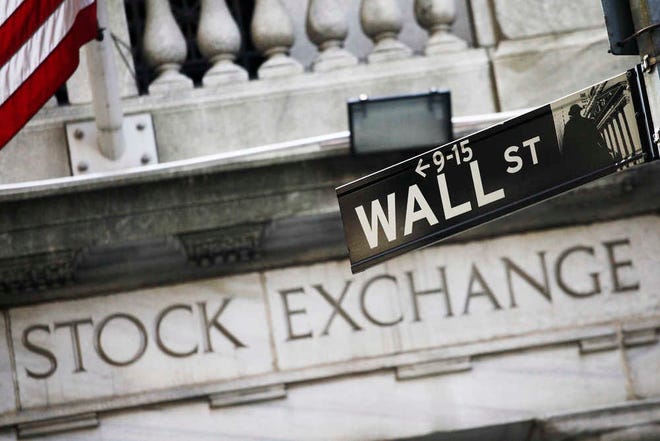 FILE - This July 16, 2013, file photo, shows a Wall Street street sign outside the New York Stock Exchange. Global stock markets posted solid gains Monday, Dec. 21, 2015, at the start of a trading week that's likely to see trading levels depressed by Christmas. Spanish stocks fell sharply after an election saw the ruling party lose its overall majority amid a groundswell of support for two upstart parties. (AP Photo/Mark Lennihan, File)