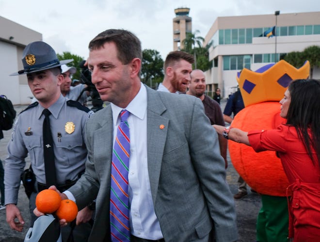 Clemson coach Dabo Swinney walks Saturday, Dec. 26, 2015, after the team arrived in Fort Lauderdale, Fla. Clemson plays Oklahoma in the Orange Bowl NCAA college playoff semifinal Dec. 31 in Miami.