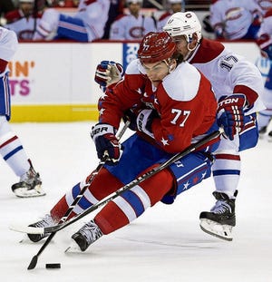 The Capitals' T.J. Oshie tries to move the puck despite being closely guarded by the Canadiens' Torrey Mitchell in the first period.