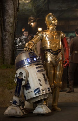 This photo provided by Disney shows, R2-D2, left, and Anthony Daniels as C-3PO, in a scene from the new film, "Star Wars: The Force Awakens," directed by J.J. Abrams. (David James/Disney/Copyright Lucasfilm 2015 via AP)