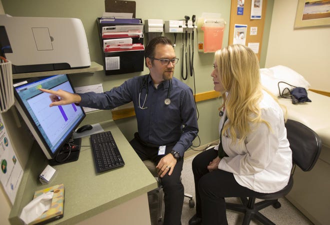 Dr. Stephen Hallas (left) consults with Maci Pfaffenberger, a student studying to become a physician assistant, during a day of working with patients at PeaceHealth Medicine Group, Santa Clara Clinic on River Road in Eugene. (Chris Pietsch/The Register-Guard)