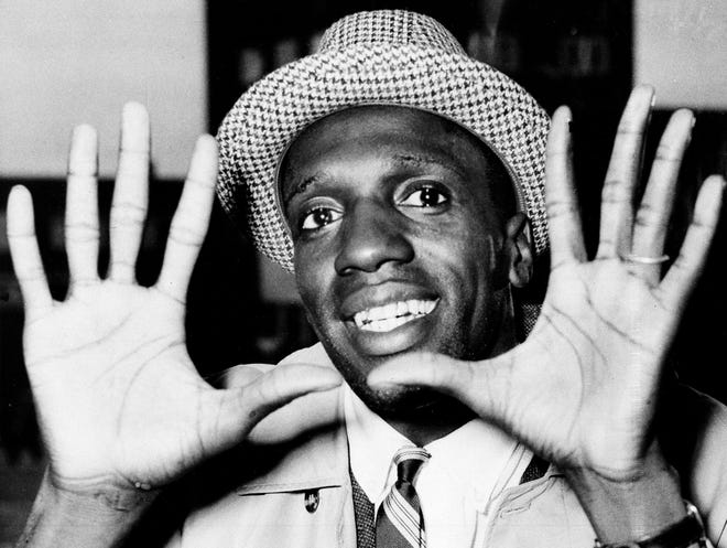 FILE - In this May 17, 1959, file photo, Meadowlark Lemon, of the Harlem Globetrotters, shows off his large hands on arrival in London where the team was to perform at the Empire Pool in Wembley for a week. Lemon, known as the Globetrotters' "clown prince" of basketball, died Sunday, Dec. 27, 2015, in Scottsdale, Ariz. He was 83. (AP Photo/File)