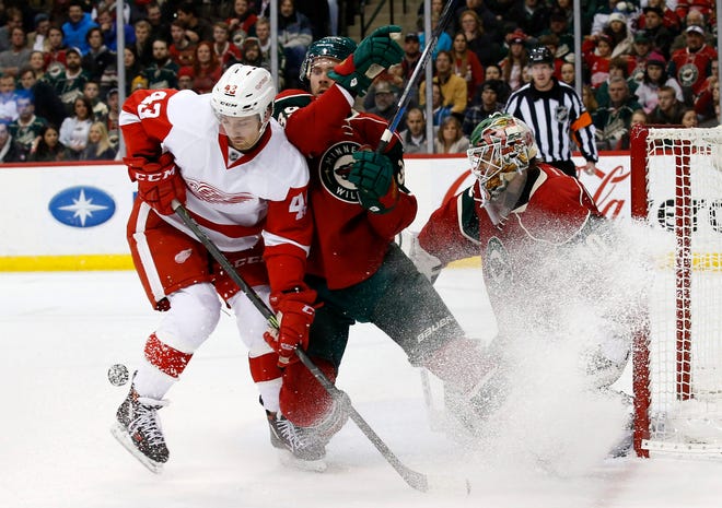 Detroit Red Wings center Darren Helm (43) and Minnesota Wild defenseman Nate Prosser compete for the puck in front of Wild goalie Devan Dubnyk during the second period of an NHL hockey game in St. Paul, Minn., Monday, Dec. 28, 2015. (AP Photo/Ann Heisenfelt)