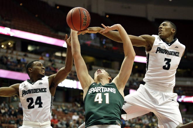 PC guards Kyron Cartwright, left, and Kris Dunn fight Michigan State's Colby Wollenman for a rebound in November's Wooden Legacy tournament. The Spartans handed the Friars their only loss of the season.
