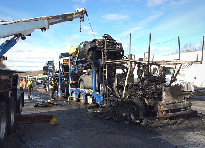 A crane is used to removed vehicles destroyed by fire after a car carrier burned on the side of the Mass Pike east in Charlton Monday morning. There were no injuries. Three cars and the truck cab were destroyed. T&G Staff/Rick Cinclair