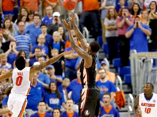 Florida State guard Dwayne Bacon (4) makes the game-winning shot over Florida Gators guard Kasey Hill (0) during the second half of an NCAA college basketball game Tuesday, Dec. 29, 2015, in Gainesville, Fla. Florida State won 73-71.