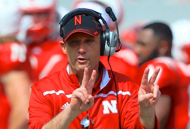 FILE - In this April 11, 2015, file photo, Nebraska head coach Mike Riley signals during the annual NCAA college football Red-White spring game in Lincoln, Neb. The move toward allowing wireless communication between coaches and players on the field in college football is on hold after a plan to experiment with the technology in a few of this year's bowl games was scrapped. Riley said he's disappointed he won't be able to use the technology in the Foster Farms Bowl against UCLA on Saturday, Dec. 26, 2015. Nebraska and UCLA both had wireless coach-to-player communication in spring practices, and their game will be played in an NFL venue, Levis Stadium in Santa Clara, Calif. (AP Photo/Nati Harnik, File)