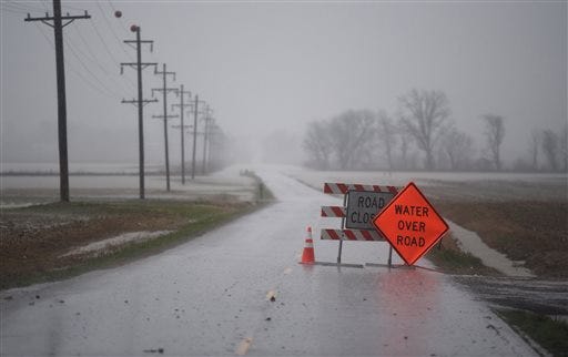 Heavy rain and fog shrouds Airline Road, closed do to high water, in Henderson County, Ky., Monday, Dec. 28, 2015. The storm system that spawned tornadoes in Texas over the weekend brought winter storm woes to the Midwest on Monday, worsening flooding already blamed for more than a dozen deaths and prompting hundreds of flight cancellations. (Mike Lawrence/The Gleaner via AP)