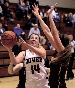 Dover High School’s Meghan May drives to the basket as John Glenn’s Gabbi Blair defends in Monday’s game in Dover. May scored nine points and Dover won 41-37.